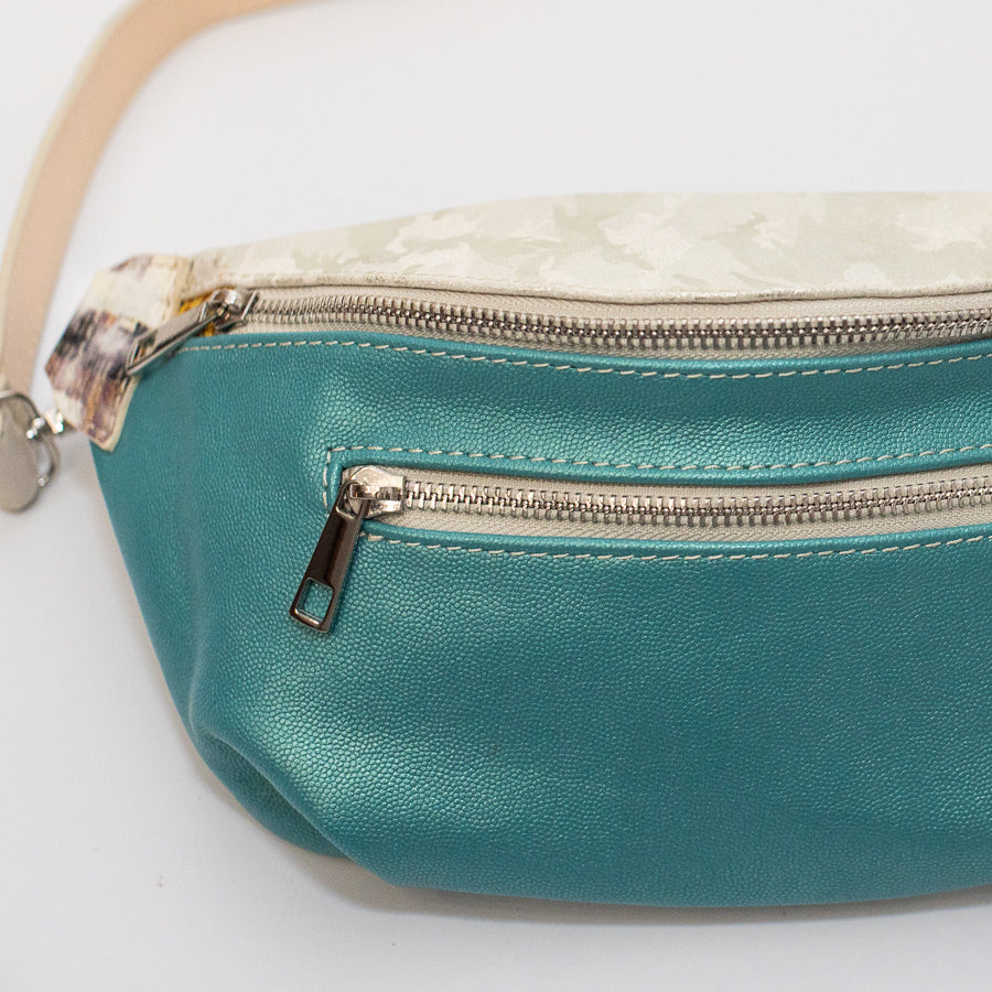 Close-up image of Ava crossbody bag in Laguna featuring iridescent teal Italian leather and silver sipper hardware
