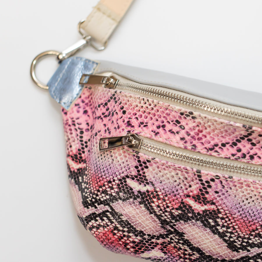 Close-up image of Ava crossbody bag in Pink Martini featuring pink snakeskin Italian leather and silver zipper hardware