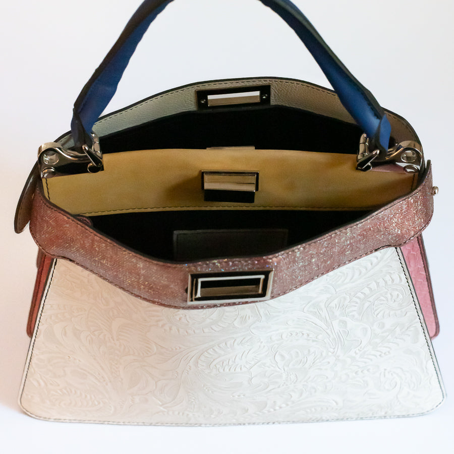 Interior image of Charlotte handbag featuring dual structured compartments and opened turn-lock clasp