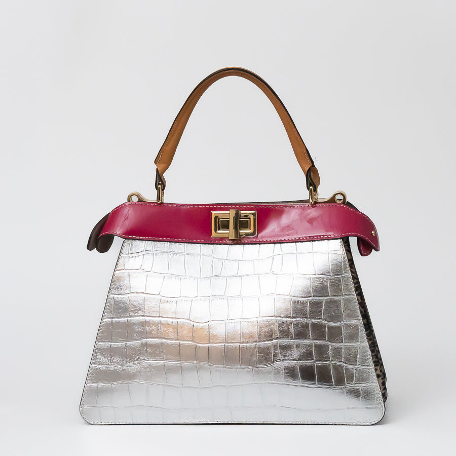 Charlotte handbag in Villa Rosa featuring silver iridescent textured Italian leather with a pink accent strip and a turn-lock clasp