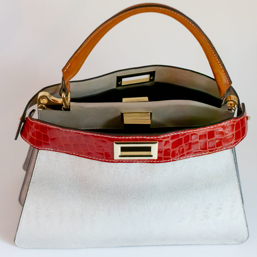 Interior image of Charlotte handbag in Neve Rossa featuring dual structured compartments and opened turn-lock clasp