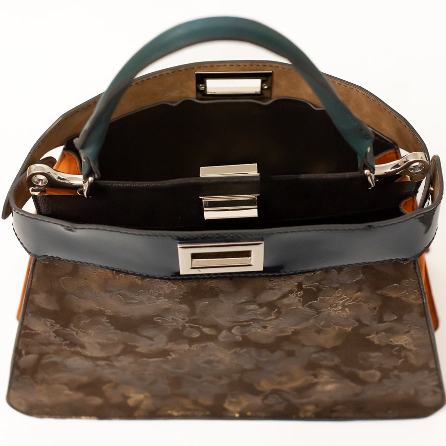 Interior image of Charlotte handbag in Bronzo Fiore featuring dual structured compartments and opened turn-lock clasp