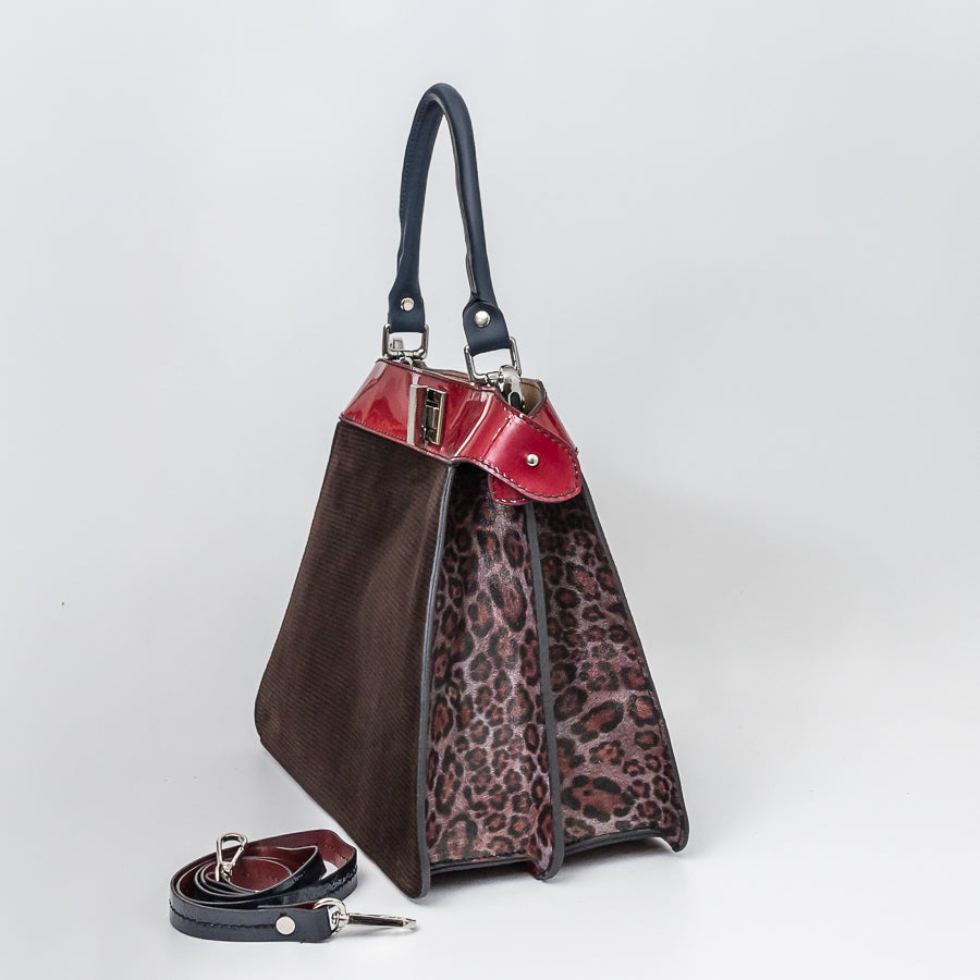 Angled image of Charlotte handbag in Belissima featuring structured accordion panels with cheetah printed Italian leather