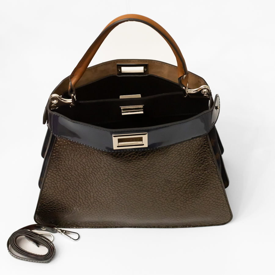 Interior image of Charlotte handbag in Azzurra featuring dual structured compartments and opened turn-lock clasp and extra strap