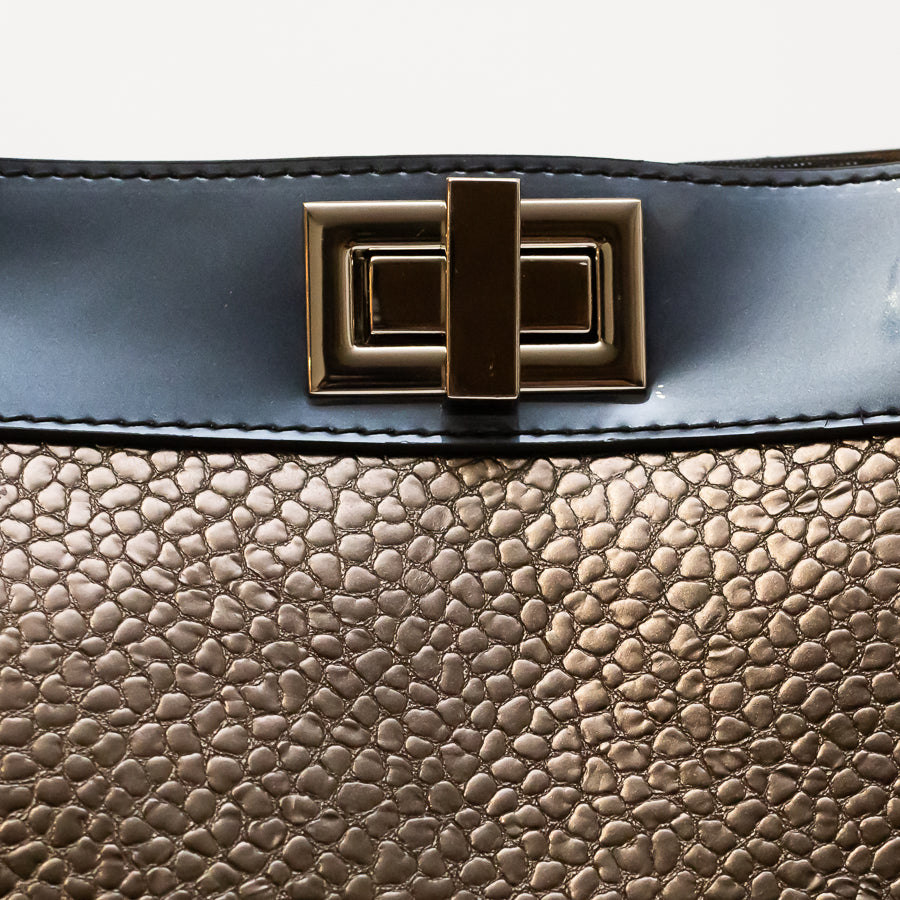 Close up image of lock-turn clasp on Charlotte bag in Azzurra