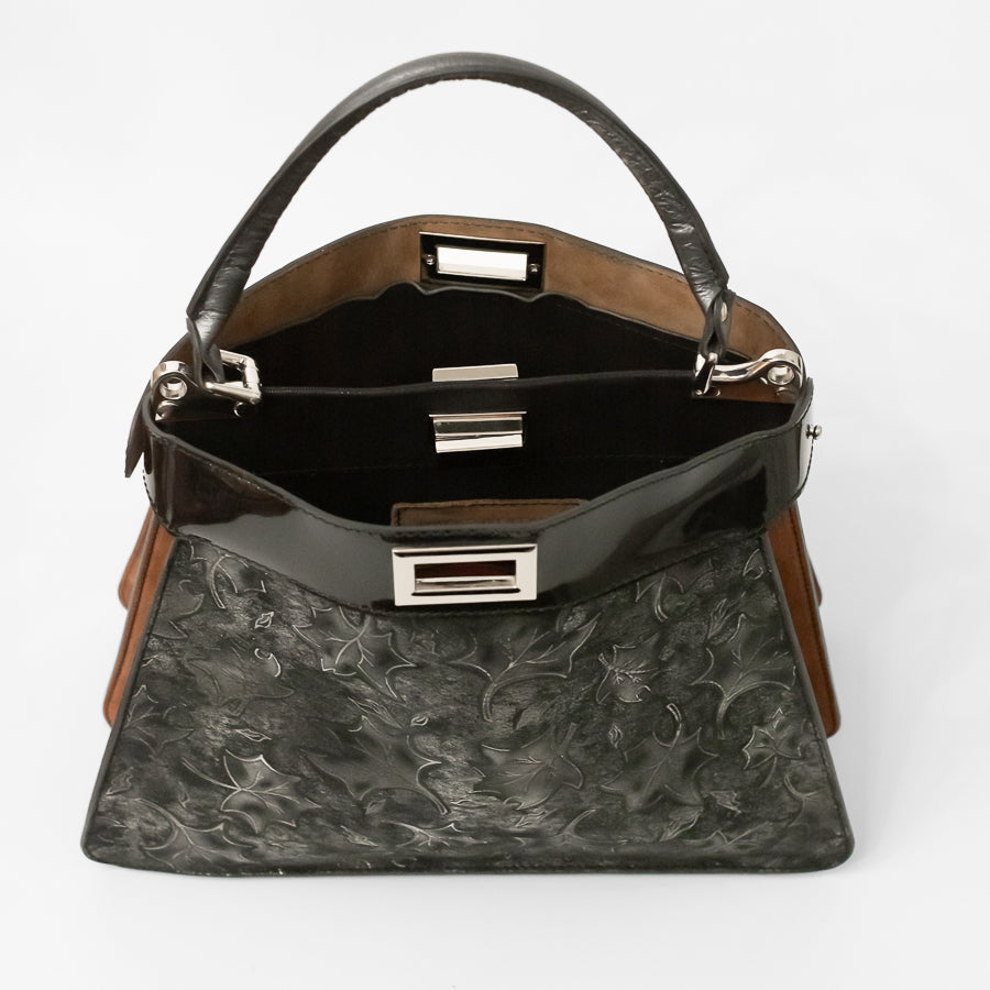 Interior image of Charlotte handbag in Midnight Garden featuring dual structured compartments and opened turn-lock clasp