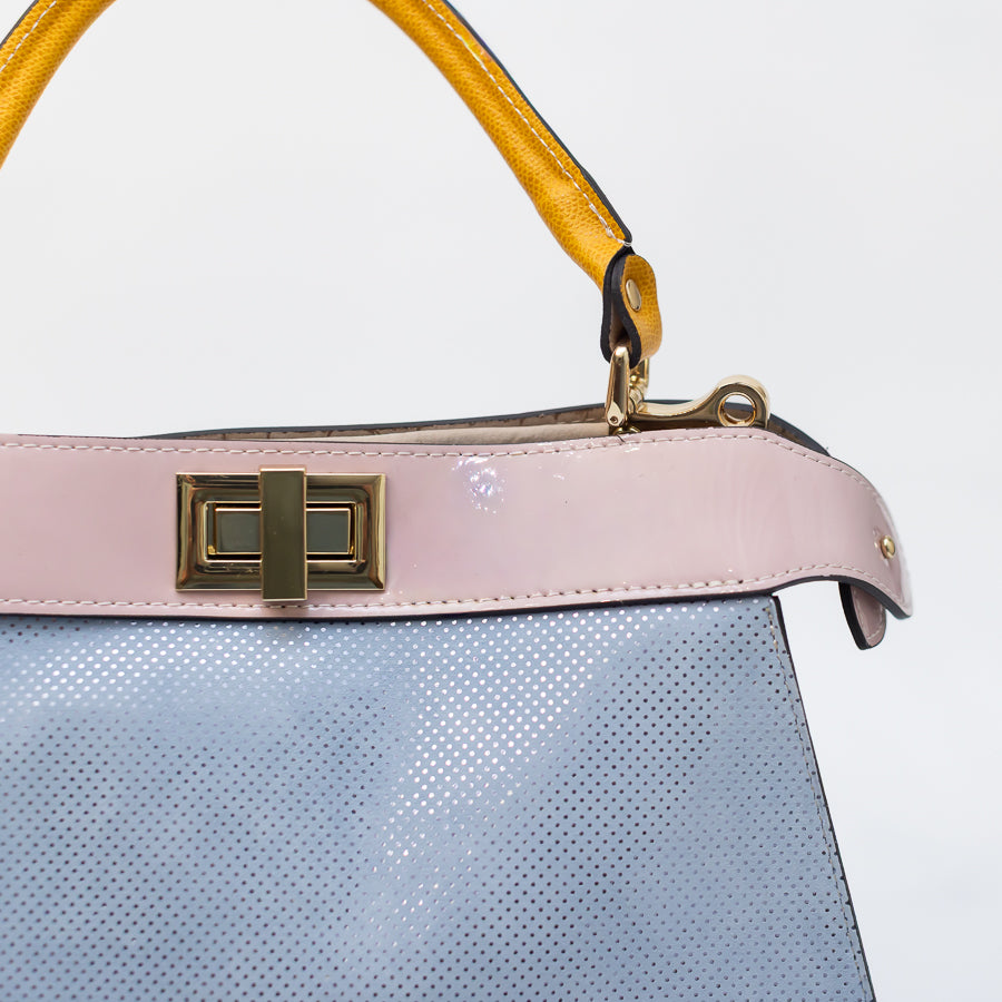 Close up image of Charlotte handbag in Cortona featuring turn-lock clasp and pink accent trim