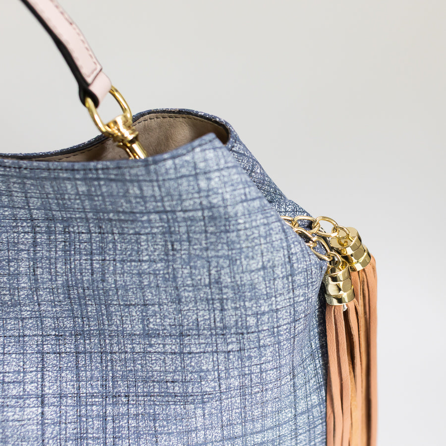 Close-up image of Lily handbag in Blue Linen featuring gold hardware and brown tassel