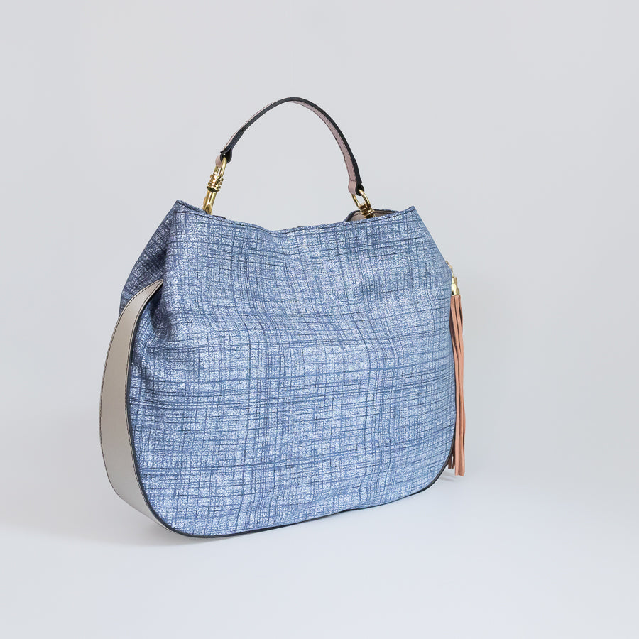 Side view of Lily handbag in Blue Linen featuring white leather bottom