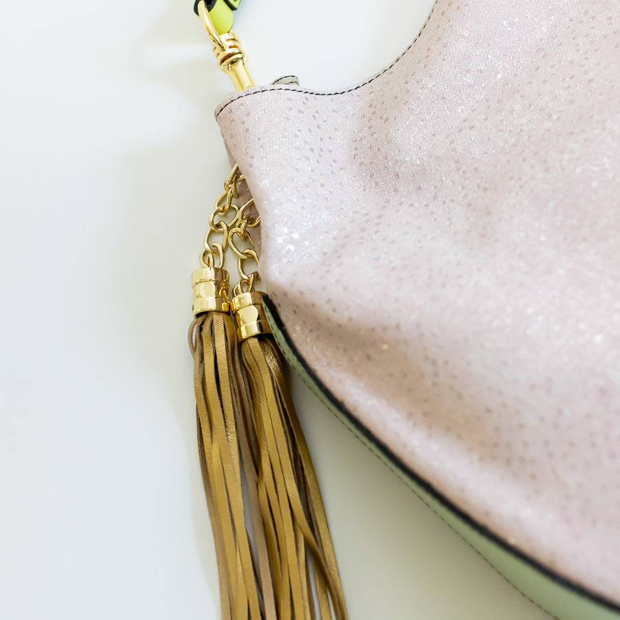 Close-up shot of Lily handbag Starlight featuring the gold tassle and shimmering pink leather