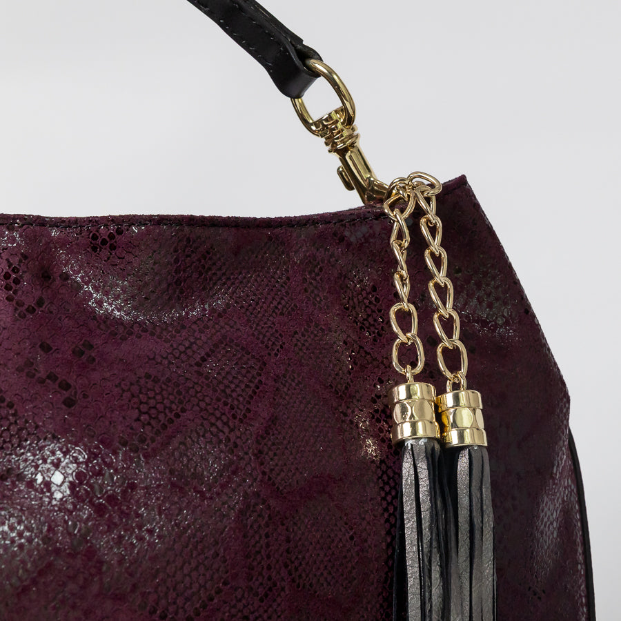 Close-up image of Lily Midnight Fig handbag featuring gold hardware and tassel detail