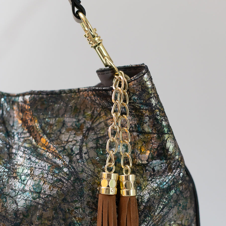 Close-up image of Lily handbag in After Midnight featuring gold hardware and multicolor iridescent leather