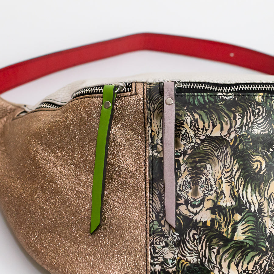 Close-up image of Madeline crossbody bag in Midnight Bazaar featuring red strap and pink and green zipper
