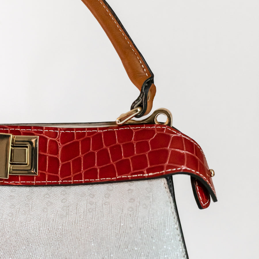 Close up image of Charlotte handbag in Neve Rossa featuring animal textured red Italian leather and gold hardware