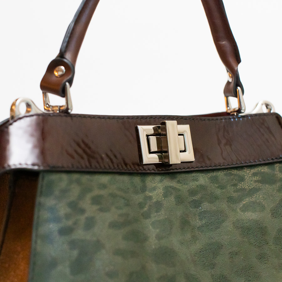 Close-up image of Charlotte handbag in Cypress featuring green cheetah print Italian leather and turn-lock clasp