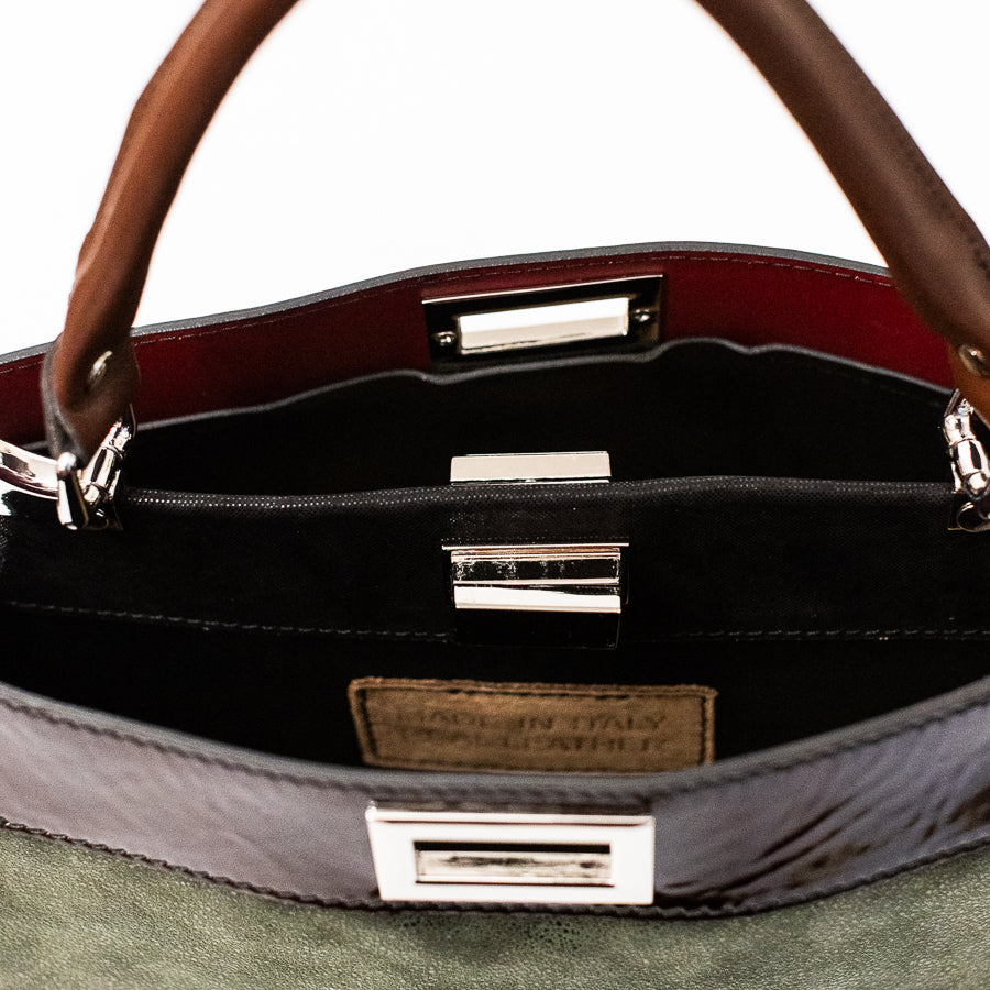 Interior image of Charlotte handbag in Cypress featuring dual structured compartments and opened turn-lock clasp