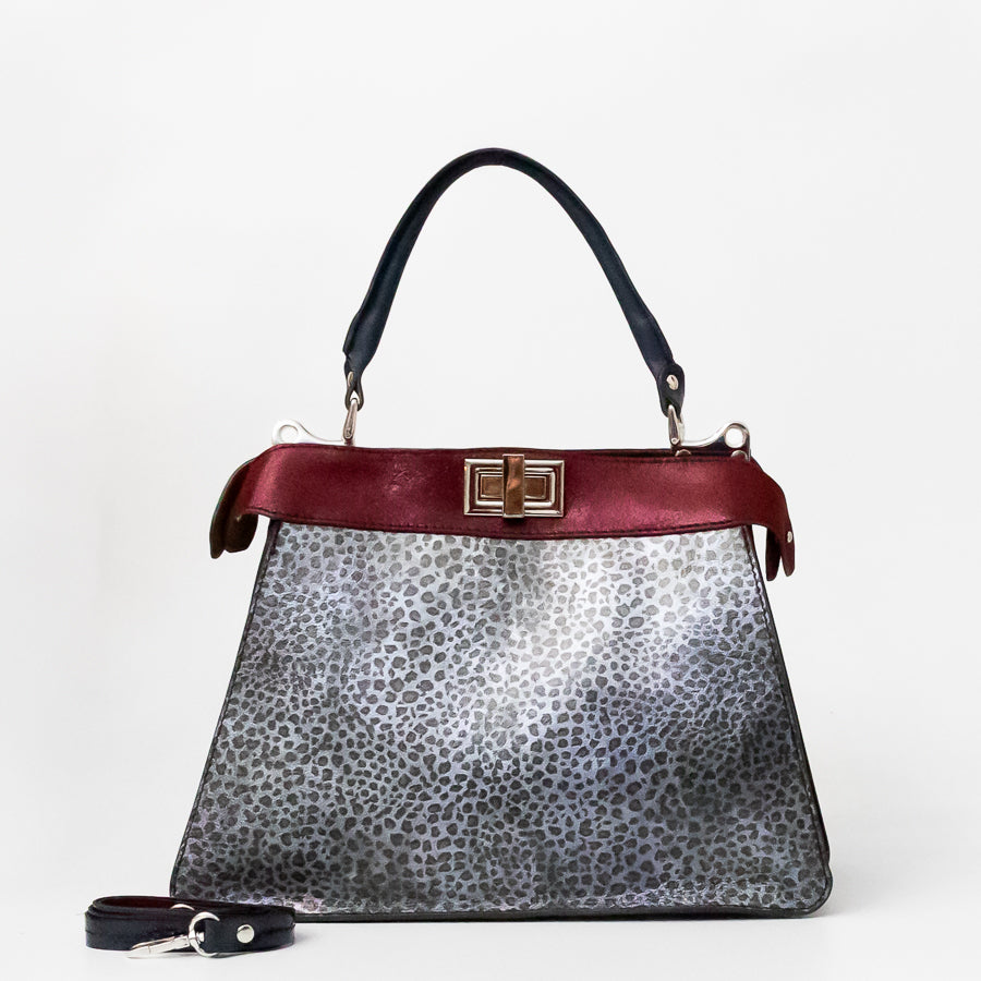 Charlotte handbag in Argenta featuring silver cheetah printed Italian leather and an iridescent red accent trim and turn-lock clasp hardware