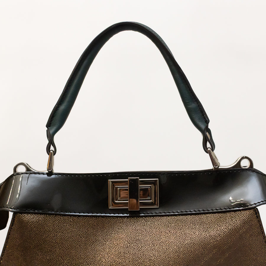 Close-up image of Charlotte handbag in Afterglow featuring structured top handle and turn-lock clasp