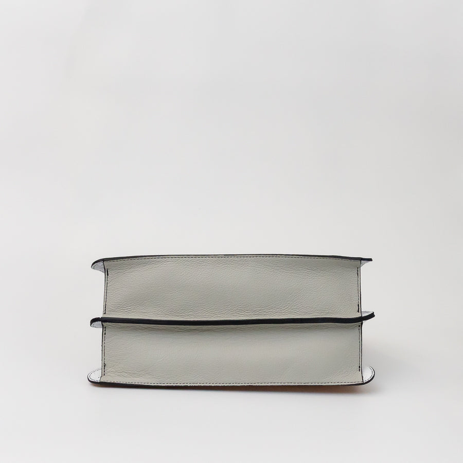Bottom image of Charlotte handbag in Champagne Piazza featuring white Italian leather
