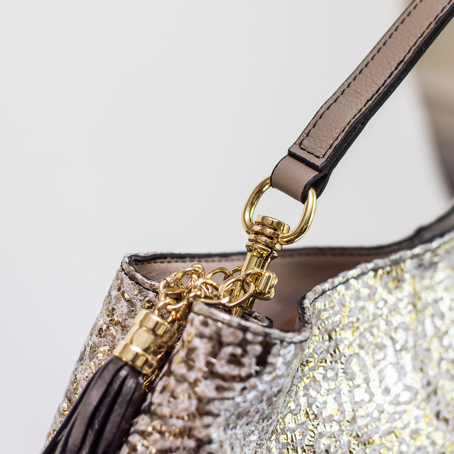 Close-up image of Lily handbag in Lunaria featuring brown leather and gold hardware