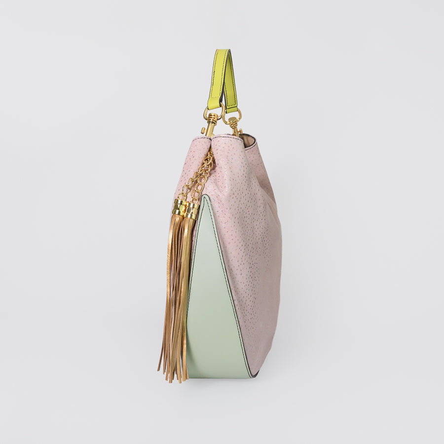 Side view of Lily handbag in Starlight featuring neon green  leather handle and mint green leather on the bottom and gold tassel