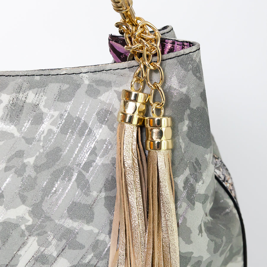 Close-up image of Lily handbag in Petal Kiss featuring grey patterened leather and gold tassel