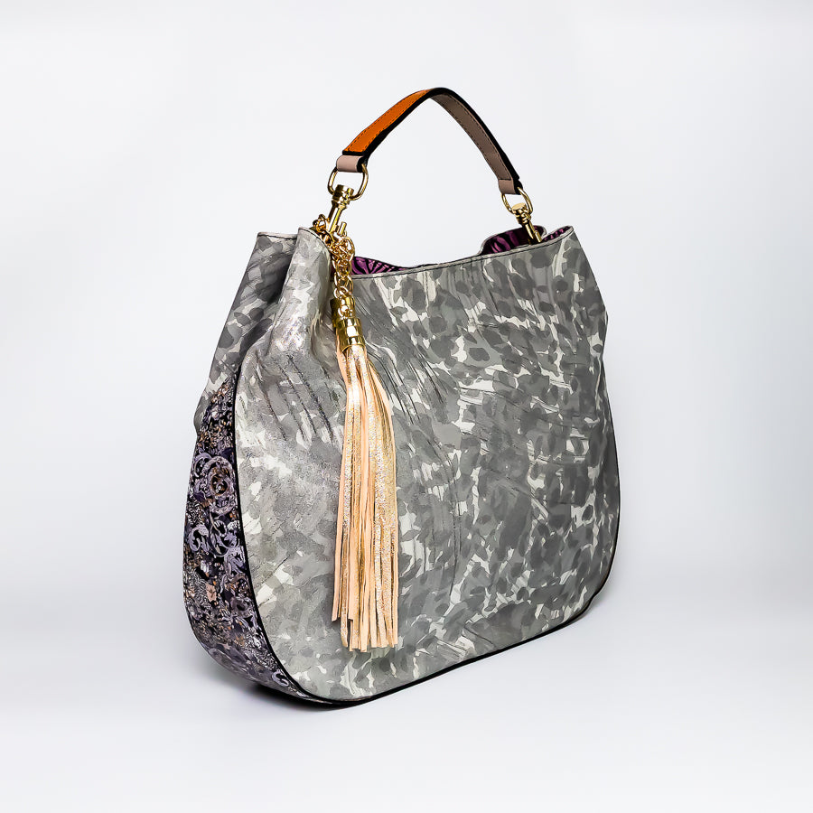 Angled view of Lily handbag Petal Kiss featuring gold tassel and intricate multicolored leathers