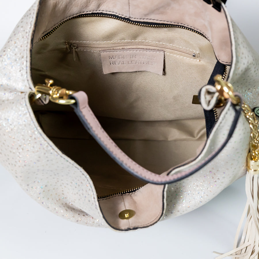 Interior image of Lily handbag in Champagne Snow featuring gold harware and zipper and smaller interior zipped pocket
