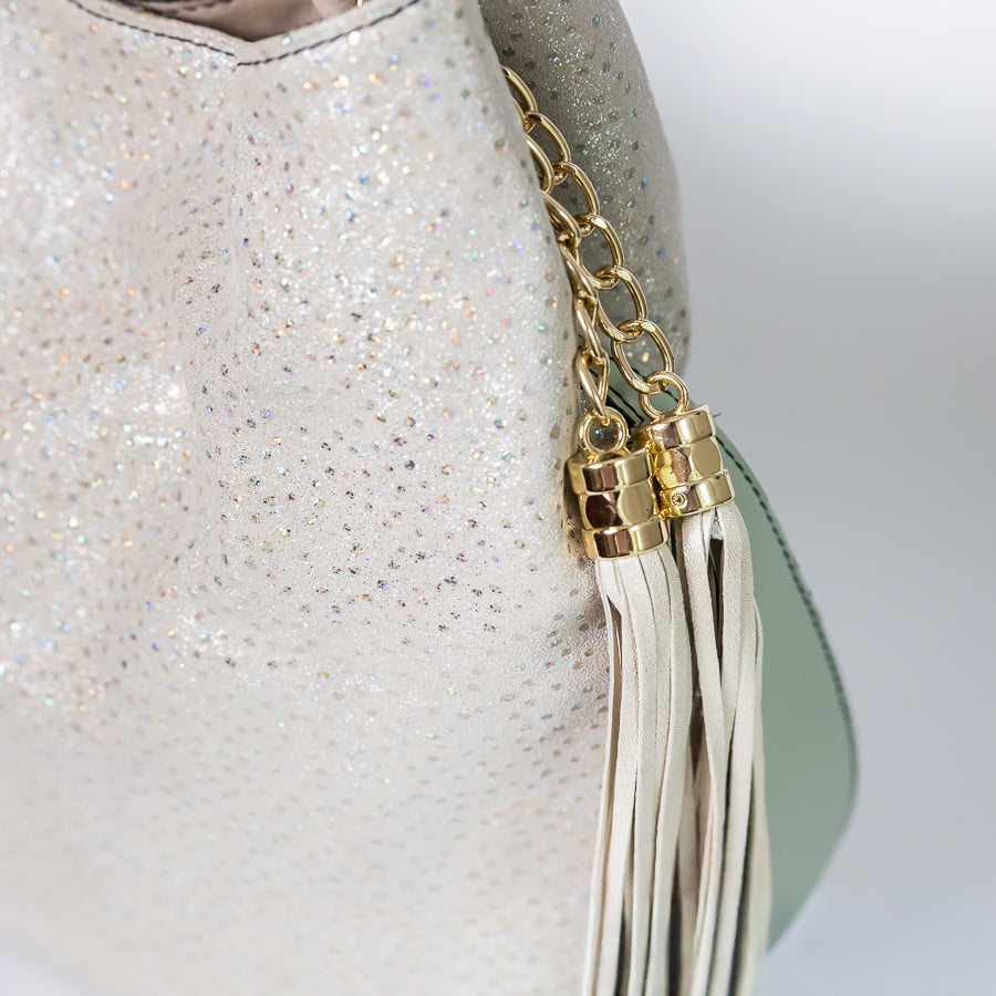 Close-up view of Champagne Snow Lily handbag iridescent Italian leather featuring gold and white tassel