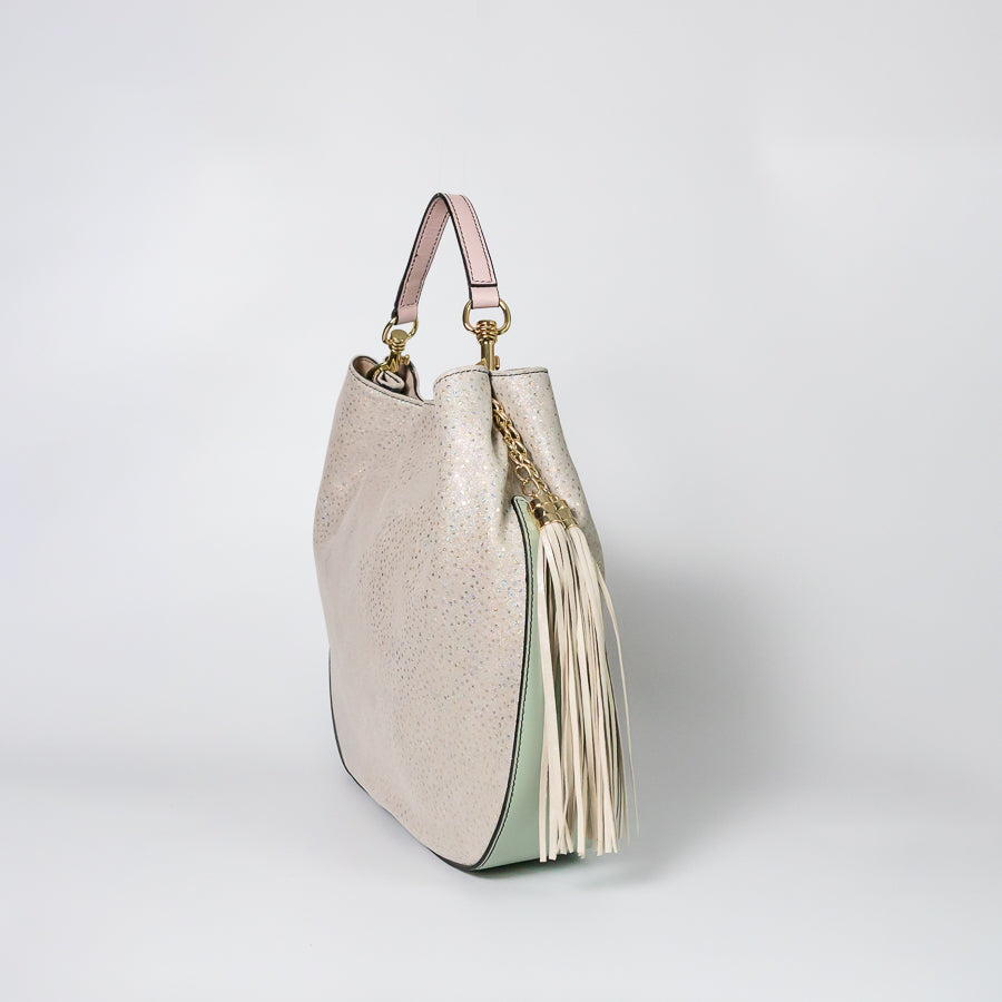 Side image of Lily handbag in Champagne Snow featuring ming green leather bottom and matching white tassel