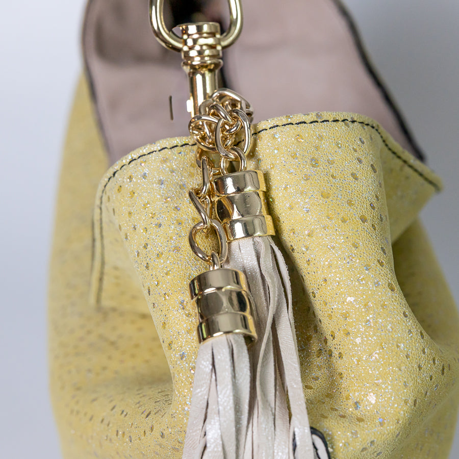 Close-up image of Lily handbag Limoncello featuring iridescent Italian leather and gold and white tassel