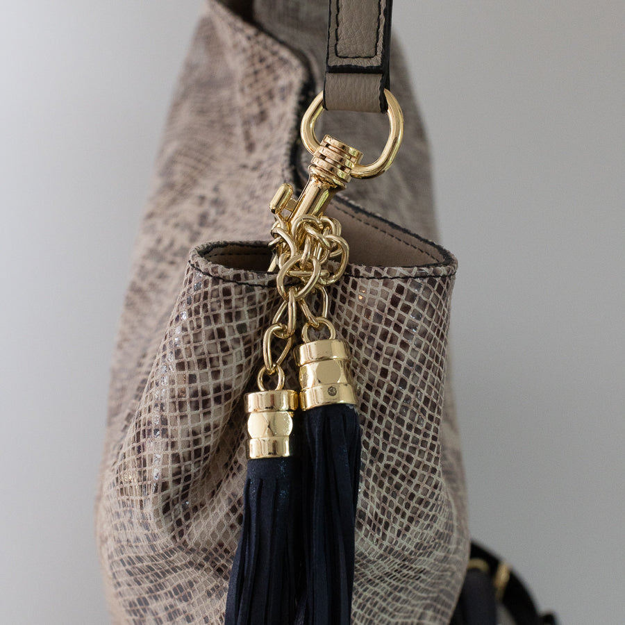 Close-up image of Lily handbag in Saint Tropez featuring gold hardware and blue tassel