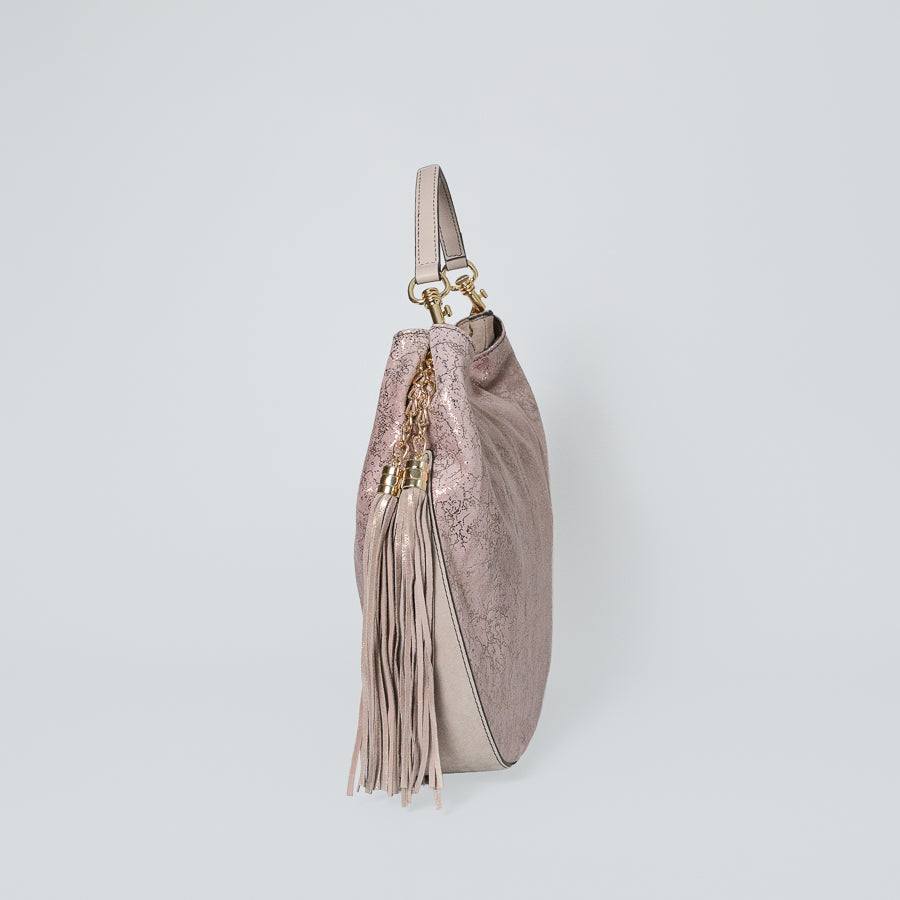 Side view of Lily handbag in Rosé All Day feauting pink tassel and matching white leather on handle and bottom