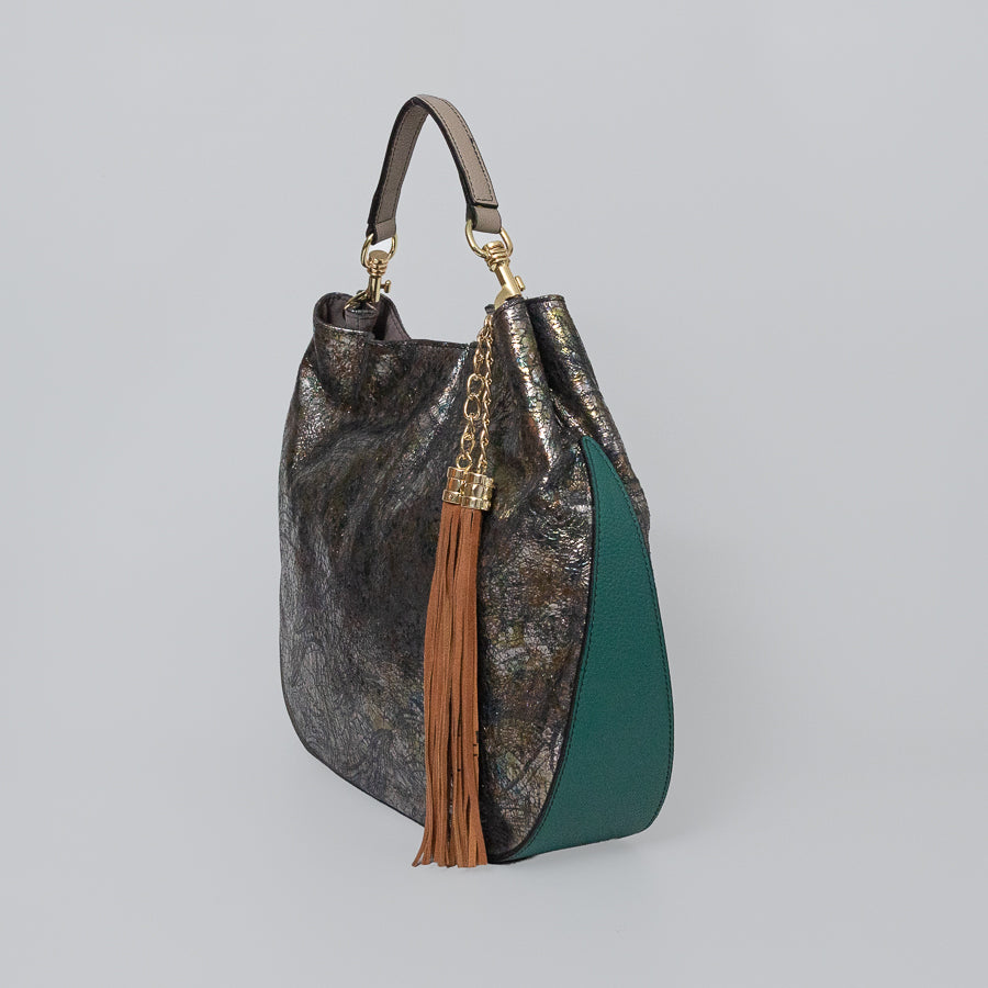 Side view of Lily handbag in After Midnight featuring brown tassel and teal bottom leather
