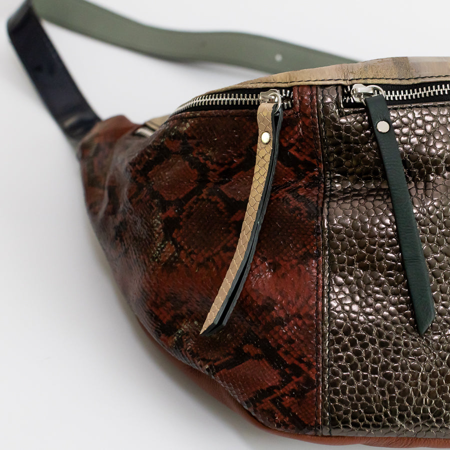 Close-up image of Madeline crossbody bag featuring snakeskin Italian leather and beige and green leather zippers