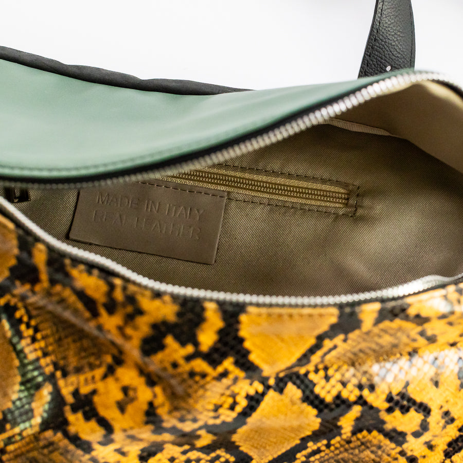 Interior view of Madeline crossbody bag in Ambra featuring interior zipped pocket and made in Italy real leather tag