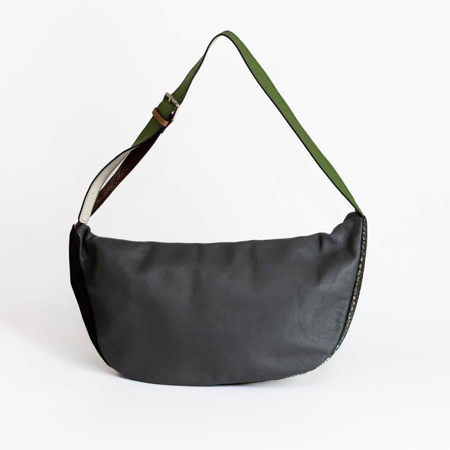 Back view of Madeline crossbody bag in Absinthe featuring black Italian leather and green adjustable strap