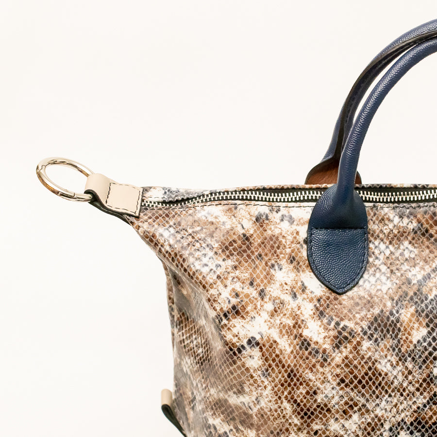 Close-up image of Vera handbag in Desert sands featuring gold o-ring clasp and gold zipper hardware