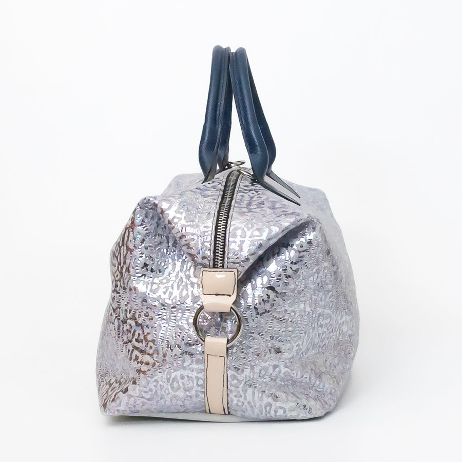 Side image of Vera handbag in Moonlit Riviera featuring silver o-ring secured side straps and structured top handles