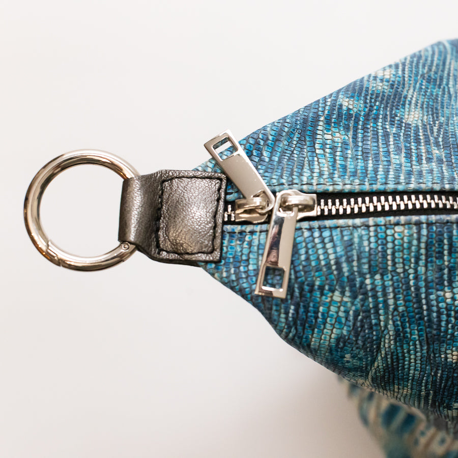Close-up image of Vera handbag in Amalfi Coast featuring gold zipper hardware and gold o-ring clasp
