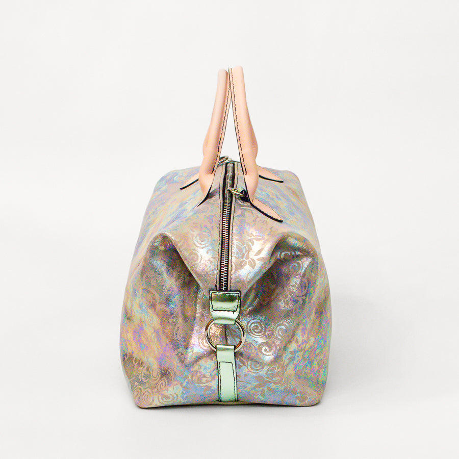 Side image of Vera handbag in Opaline Garden featuring silver o-ring secured straps and structured top handles