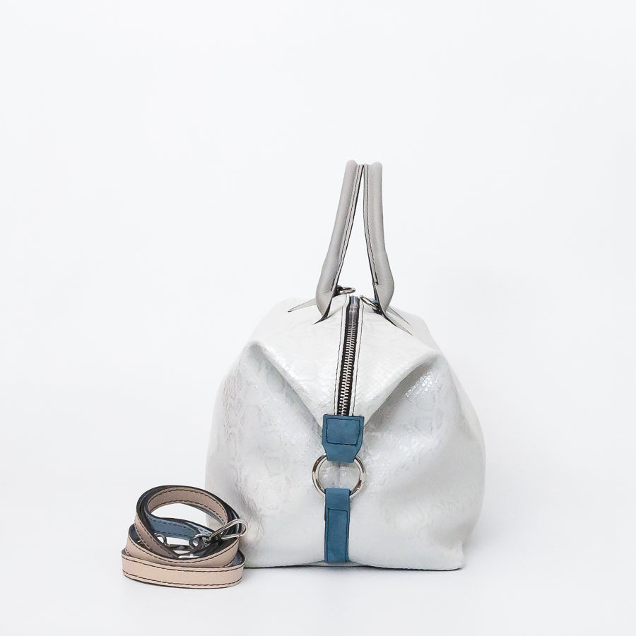 Side image of Vera handbag in Winter Lace featuring side straps with silver o-ring clasp and extra strap