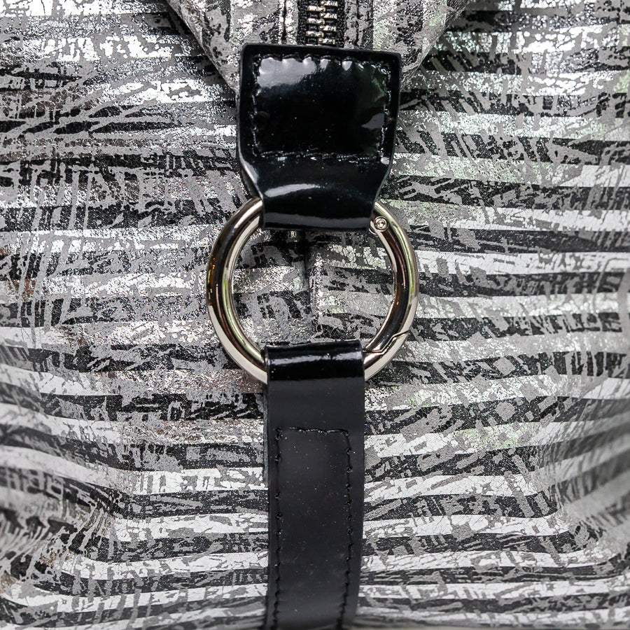 Close-up image of Vera handbag in Silver Coast featuring side straps featuring silver o-ring clasp on black Italian leather straps