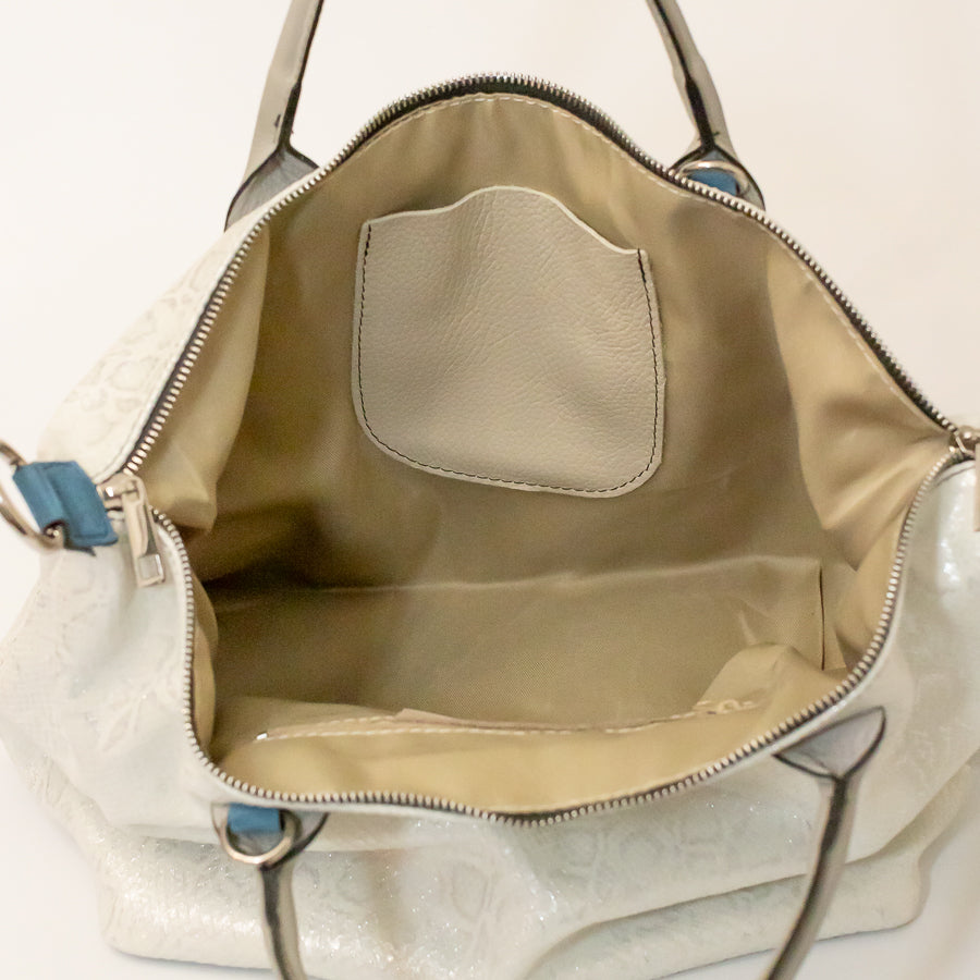 Interior image of Vera handbag in Winter lace featuring interior pocket and silver zipper hardware